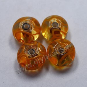 Bead,lampworked glass, clear and orange with gold-colored foil painted swirls, 16x10mm rondelle. Sold per pkg of 500.