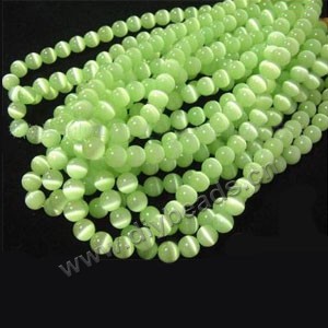 Bead, cat's eye glass,peridot, 6mm round, quality grade. Sold per 14.5-inch strand.