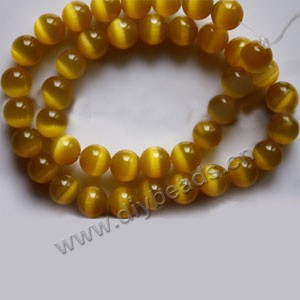 Bead, cat's eye glass,dark yellow, 10mm round, quality grade. Sold per 14.5-inch strand.