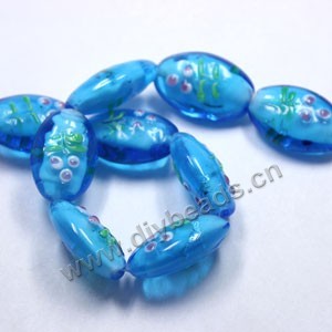 Bead, lampworked glass,clear/blue/pink, 26x18mm puffed oval with painted flower and silver swirls. Sold per pkg of 300.