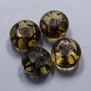 Bead,lampworked glass, clear and black with gold-colored foil painted swirls, 16x10mm rondelle. Sold per pkg of 500.